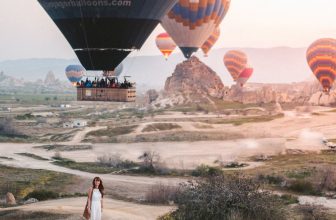 woman standing under hot air balloons